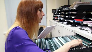 A woman looking in a filing cabinet